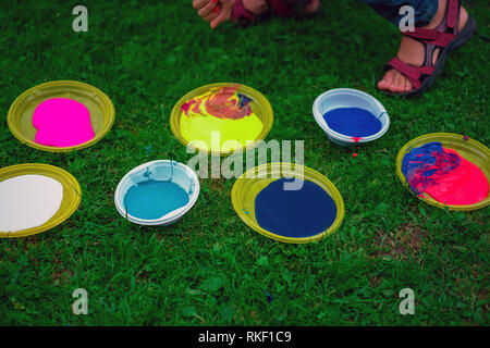 Gelbe Schilder auf dem grünen Rasen mit unterschiedlichen Acrylfarbe in outdoor Workshop für Kinder Stockfoto