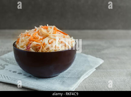Mit Karotten in einem keramischen Cup Sauerkraut. Stockfoto