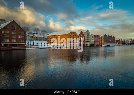 Alte hölzerne Gebäude, Zeitschriften, am Ufer des Flusses Nidelva, Winter in Trondheim, Norwegen. Stockfoto