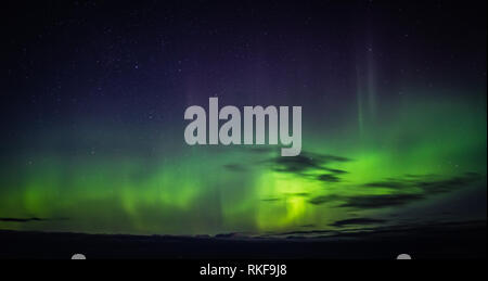 Norden leuchtet Aurora Borealis von Atlantic Ocean Road - Atlanterhavsveien im Winter Nacht gesehen. Norwegische Winter. Schönen Sternenhimmel und Lämpchen leuchten grün. Stockfoto