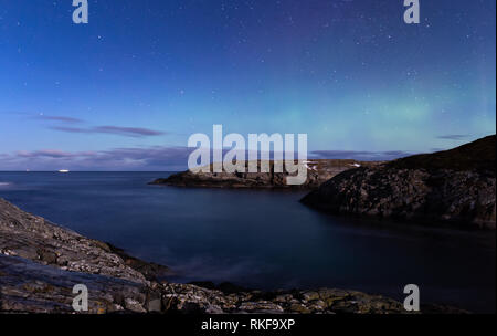 Norden leuchtet Aurora Borealis von Atlantic Ocean Road - Atlanterhavsveien im Winter Nacht gesehen. Norwegische Winter. Schönen Sternenhimmel und Lämpchen leuchten grün. Stockfoto