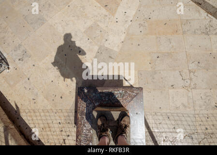 Die Füße und die Schatten eines Menschen auf einer Plattform an der Spitze des el Miguelete, der Glockenturm der Kathedrale von Valencia in Valencia, Spanien stand. Stockfoto