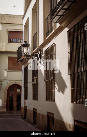 Eine Straßenlaterne auf der Seite eines Gebäudes in der Altstadt von Valencia, Spanien. Stockfoto