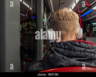 Nicht erkennbare Mann Musik hören oder Podcast im Bus Stockfoto