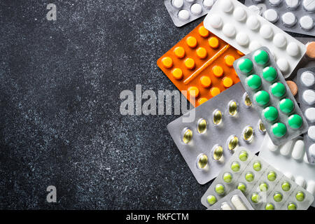 Farbige Pillen und Tabletten auf schwarz Ansicht von oben. Stockfoto