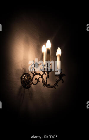 Alte elektrische Lampe auf eine Gekälkte Wand mit dunklen Hintergrund Stockfoto
