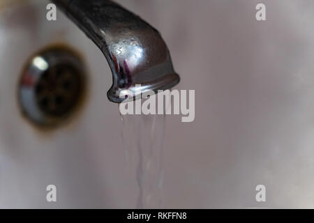 Wasser leckt aus alten Metall in der Badewanne tippen. Verschwendung von Wasser Konzept Stockfoto