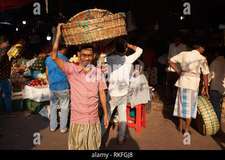 Ein Torhüter mit seinem Korb bei Crawford Market von Mahatma Jyotirao Phuke Markt, ein Großmarkt für Obst und Gemüse in Mumbai, Indien Stockfoto