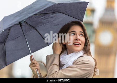 Mädchen oder Junge Frau Tourist im Urlaub mit einem Regenschirm mit Big Ben im Hintergrund, London, England, Großbritannien Stockfoto