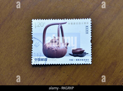 CHINA - ca. 2019: ein Stempel in China gedruckt zeigt 2019-3 40. diplomatischen Beziehungen mit Portugal Stempel dunkel-rot emailliert Keramik Teekanne ca. 2019. Stockfoto