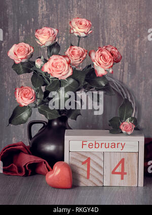 Valentinstag noch Leben mit Holz- Kalender, Rosen und Herzen auf rustikalem Holz Stockfoto