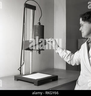 1950er Jahre, Dame mit einem Foto enlarger, Gerät in dieser Ära verwendet größeren Fotos von der ursprünglichen fotografischen Filmen Negativ zu drucken. Stockfoto