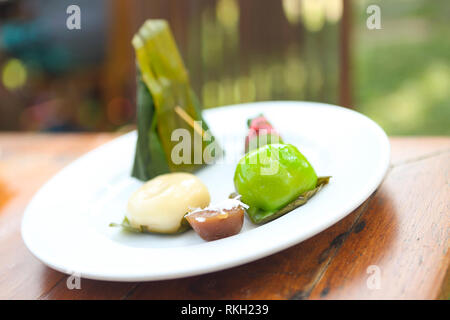 Traditionelle thailändische Desserts, klebrigen Reis Pudding in Bananenblätter gewickelt Stockfoto