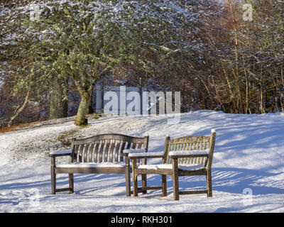 Zwei schneebedeckten Bänken auf dem Gelände des St Ninian's Scottish Episcopal Church, Glen Urquhart, Highland, Schottland Stockfoto