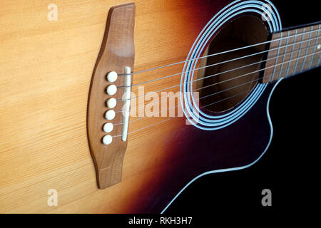 Klassische akustische sechs Saiten Gitarre sunburst Farbe Top von mit Cutaway Fragment auf schwarzem Hintergrund Seitenansicht closeup isoliert Fichte Stockfoto