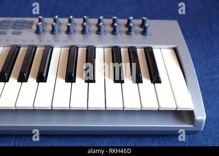 Elektronische Synthesizer Keyboard mit vielen Drehknöpfe denim Hintergrund Draufsicht closeup Stockfoto