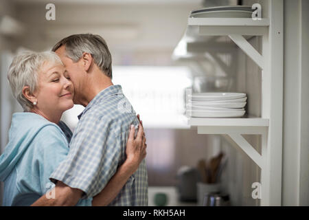 Herzlichen reifes Paar zärtlich in der Küche umfassen. Stockfoto