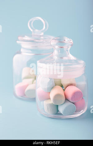 Glas mit bunten Marshmallows auf einfachen Hintergrund gefüllt Stockfoto