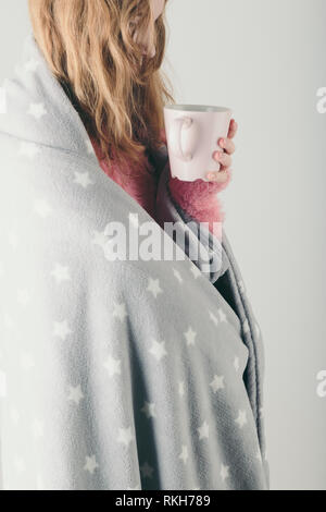 Junge Frau kalt erwischt hat, Tag, kranken Tag, in der Decke eingewickelt, hält Tasse Kräutertee. Profil Hochformat Stockfoto