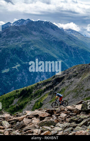 Ein Mann reitet ein Mountainbike auf einer felsigen Trail in der Österreichischen Resort von Sölden im Ötztal im Sommer. Stockfoto