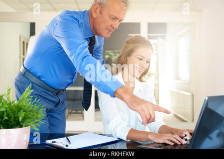 Schuss der Jungen financial Assistant Geschäftsfrau gemeinsam mit Executive Geschäftsmann. Junge professionelle Geschäftsfrau sitzen vor dem noteb Stockfoto