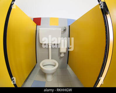 Ein wc in der kleinen Hütte im Kindergarten mit gelben Tür Stockfoto