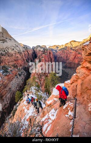 Junge Frau Wanderungen auf der Via ferrata in absteigender Reihenfolge von der Angels Landing, Angels Landing Trail, im Winter, Zion Canyon Stockfoto