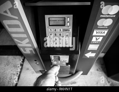 BASEL, SCHWEIZ - 22.MÄRZ 2018: die Sicht der männlichen Hand eine Transferwise Kreditkarte aus einem Parkplatz Teller Machine nach der Zahlung angenommen wird - Schwarz und Weiß Stockfoto