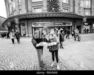 Straßburg, Frankreich - Dec 29, 2018: Touristen, Vater und Tochter auf den Stadtplan vor der Galeries Lafayette Shopping mall Center im Zentrum von Straßburg, Schwarz und Weiß Stockfoto