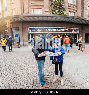 Straßburg, Frankreich - Dec 29, 2018: Touristen, Vater und Tochter auf den Stadtplan vor der Galeries Lafayette Shopping mall Center im Zentrum von Straßburg, quadratischen Bild Stockfoto