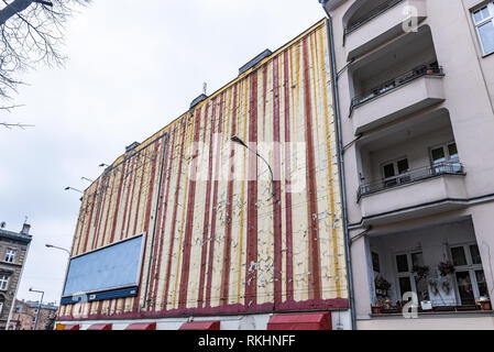 Die bröckelnden Abblättern alter Lackierung und Alterung auf einer alten Mauer Mietshaus mit Straßenlaterne. Die Malerei beginnt zu verblassen und lose Farbe. Stockfoto