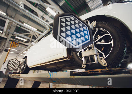 Ein Auto auf dem Auto Lenkrad Balancer und kalibrieren Sie mit Laser Reflektor befestigen Sie auf jedem Reifen Center fahren Sie in der Garage einstellen. Stockfoto