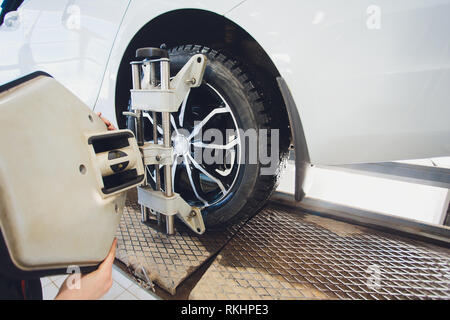 Ein Auto auf dem Auto Lenkrad Balancer und kalibrieren Sie mit Laser Reflektor befestigen Sie auf jedem Reifen Center fahren Sie in der Garage einstellen. Stockfoto