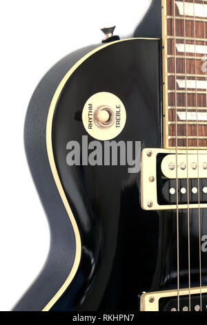 Ein Teil der Farbe Schwarz E-Gitarre auf weißem Hintergrund vertikale Ansicht Nahaufnahme isoliert Stockfoto