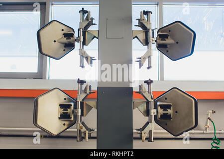 Ein Auto auf dem Auto Lenkrad Balancer und kalibrieren Sie mit Laser Reflektor befestigen Sie auf jedem Reifen Center fahren Sie in der Garage einstellen. Stockfoto