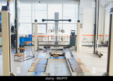 Ein Auto auf dem Auto Lenkrad Balancer und kalibrieren Sie mit Laser Reflektor befestigen Sie auf jedem Reifen Center fahren Sie in der Garage einstellen. Stockfoto