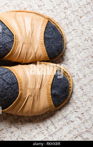 Gemütliche, komfortable, weiche Schuhe. Weibliche Füße mit Socken in Hausschuhe zu Hause Stockfoto