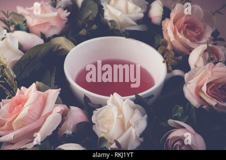 Teetasse in einem rosa und weiße Rose Wreath auf einem rosa Hintergrund Stockfoto