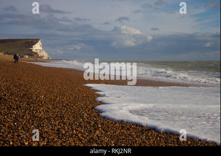 Südengland, Seaford steinigen Strand. Wilden Meer. White Cliffs (Sieben Schwestern) im Hintergrund. Stockfoto