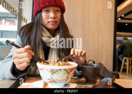 Hongkong - ca. Januar 2016: Frau bei Yoshinoya Restaurant. Yoshinoya ist ein japanisches Schnellrestaurant Kette. Stockfoto