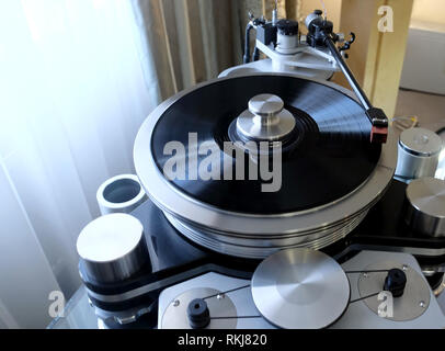 Moderne hochpräzise High-End Plattenspieler mit einer rotierenden Scheibe mit einer installierten schwarzen Vinyl record im Innenraum Stockfoto