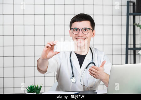 Lächelnd Apotheker Holding eine Schachtel Pillen in der Apotheke Stockfoto