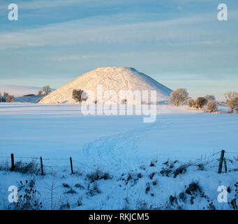 Silbury Hill im Winter Schnee bei Sonnenaufgang. Avebury, Wiltshire, England Stockfoto