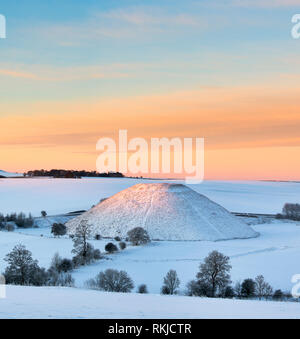 Silbury Hill im Winter Schnee bei Sonnenaufgang. Avebury, Wiltshire, England Stockfoto