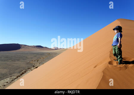 Junge kaukasier Junge spielt auf Sand Dünen bei Sossusvlei in Namibia Stockfoto