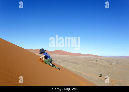 Junge kaukasier Junge spielt auf Sand Dünen bei Sossusvlei in Namibia Stockfoto