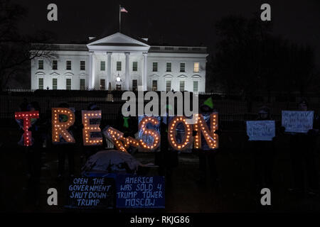 Die Demonstranten halten beleuchteten Buchstaben Anzeichen dafür, dass Lesen 'Verrat', während außerhalb des Weißen Hauses protestieren während des partiellen Regierung Abschaltung in Washington, D.C., USA, am Samstag, Jan. 12, 2019. Stockfoto