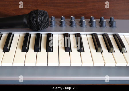 Elektronische Synthesizer Keyboard mit vielen Reglern in Silber und Schwarz Kunststoffgehäuse voice Mikrofon auf Holz- Hintergrund der Vorderansicht closeup Stockfoto