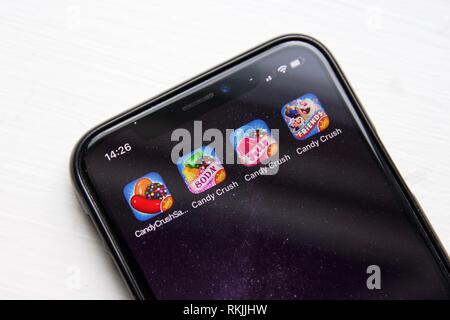 Vier Candy Crush Saga Spiele auf einem iPhone X vor einem weißen Hintergrund. Alle vier Spiele werden vom König machte. Stockfoto