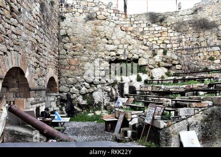 Izmir, Türkei. 28 Jan, 2019. Eine ältere Künstlerin mit Souvenirs und seine Gemälde sitzt in den Ruinen von Genoese-Ottoman fünf Tore Schloss in der Altstadt. Credit: Altan Gochre | Verwendung weltweit/dpa/Alamy leben Nachrichten Stockfoto